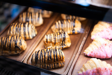 Cakes and sweets on the front of a small coffee shop, bokeh light background