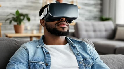 A man wearing a virtual reality headset sits on a couch while using VR - Powered by Adobe