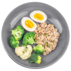 Breakfast oatmeal porridge with boiled egg and broccoli isolated on white background. top view. Healthy balanced food