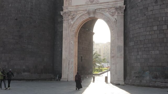 Beautiful evening photo with strong sunshine backlight of Porta Capuana entrance gate to the old town of Napoli old town. Magnificent roman gate in Naples..