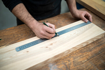 Carpenter holding a measure tape on the work bench