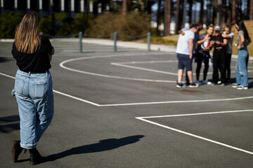 Young woman looking sad, anxious and depressed, introverting and feeling lonely, while in a group...