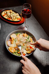 Elegant dinner with Caesar salad, red wine, and gourmet dish in a cozy ambiance