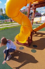 yellow children's slide in the shape of a pipe