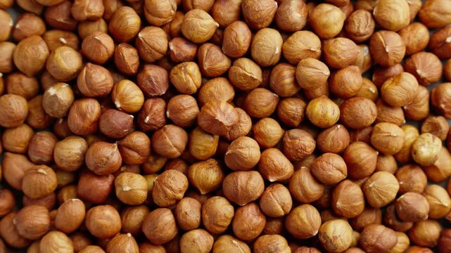 Hazelnuts heap rotating. Organic snack. Pile of hazelnuts without shell. Vegan food. Top view. Healthy nutrition. Energy product. Peeled nut. Hazelnut kernels rotating. 4K, UHD