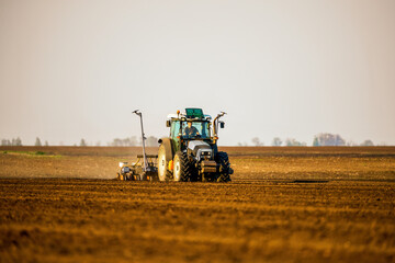 Obraz premium Farmer operating a tractor for sowing crops on fertile farmland, showcasing modern agriculture