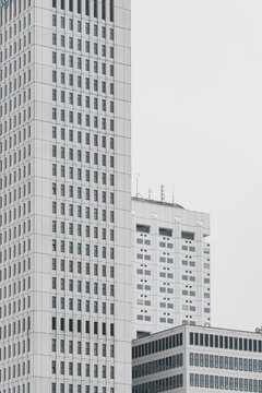 An image displaying white high-rise buildings with minimalist design elements standing against a serene sky, representing modern urban living and architectural simplicity.