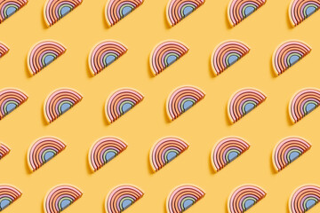 Naklejka premium Abstract figures from elements of the children's designer wooden pastel rainbow on a wooden podium on a paper background. 