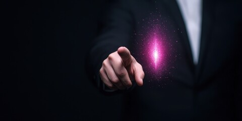 Obraz premium A businessman points at a glowing, futuristic orb in a dark setting, symbolizing innovation.