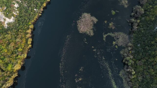 Rijeka Crnojevica river near Skadar lake in Montenegro. A winding river among the rocky mountains. Breathtaking landscape, panoramic aerial view. Yellow-green deciduous forest from a bird's-eye view
