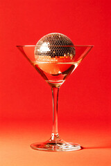 Cocktail party with disco ball on bright red color background. Disco party, retro fashion. Modern stylish vertical template for holiday card, banner, flyer, menu with space for text