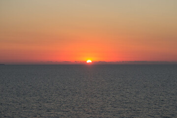 evocative image of sunset over the calm sea on a beautiful day