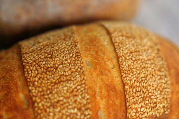 Closeup photo of crust with sesame seeds of home baked bread