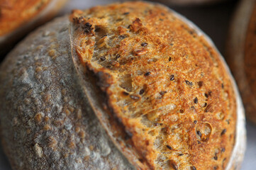 Closeup photo of crust with sesame seeds of home baked bread