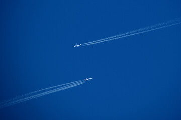 Airplanes in the blue sky with contrails. Shallow depth of field.