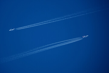 Airplanes in the blue sky with contrails. Shallow depth of field.