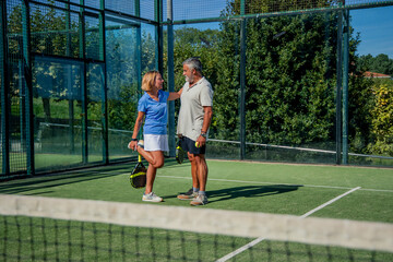 Senior elderly padel couple player stretching on court before match