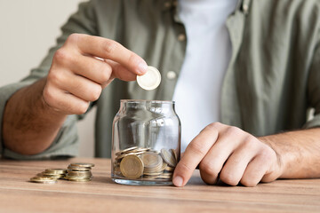 Hand Putting Coin in a Jar Full of Coins, Saving Concept