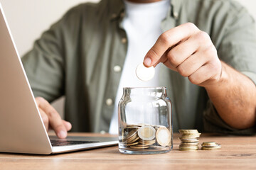 Hand Putting Coin in a Jar Full of Coins, Saving Concept