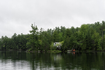 A cabin in the forest by a lake. High quality photo. Canada