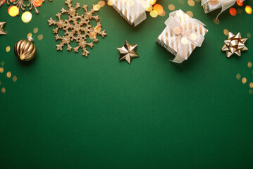 Merry Christmas and Happy Holidays greeting card, frame, banner. New Year. Noel. Golden Christmas ornaments on green background top view. Winter xmas holiday theme. Flat lay	
