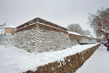 uzhhorod, ukraine - 12 JAN 2013: uzhhorod castle in winter. urban landscape. popular landmark in western ukraine. cloudy weather. snow covered walls and bastion. wintertime defence