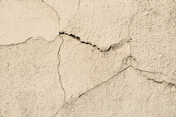 Old textured wall with curved cracks and peeling stucco. Light grey tones and antique vintage filter processing