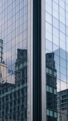 Obraz premium Reflection of modern glass skyscraper on the surface of a neighboring office building, architecture, modern