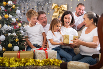 Family with children holding gifts in christmas interior