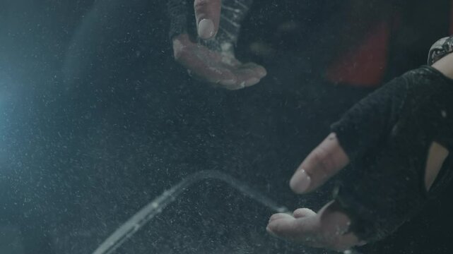 fitness woman athlete hands in gloves clapping chalk powder sportsman preparing training workout in gym ready for bodybuilding strength exercise slow motion close up. CrossFit training session