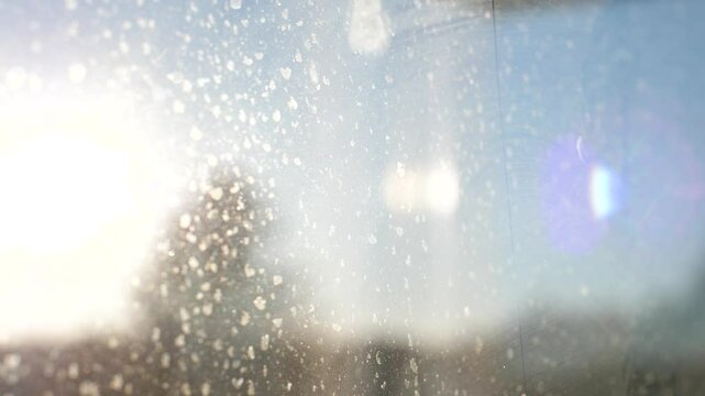 Rays of sunlight passing through a dirty window pane on a clear summer day