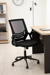 Black chair, laptop and desk in office