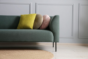 Comfortable sofa near grey wall in room