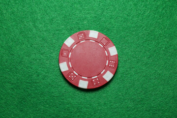 Poker chip on green table, top view