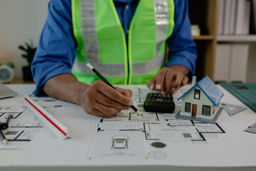 a contractor is checking the first draft in his office, architect is examining blueprint to make...