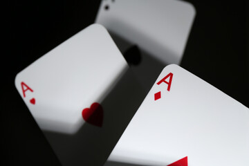 Poker game. Playing cards on black background, closeup