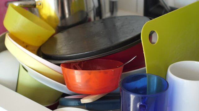Close up view of a sink full of dirty dishes, cluttered home kitchen