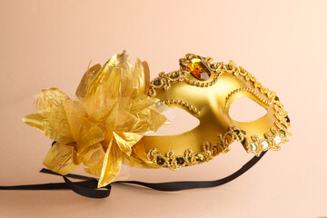 Beautiful golden carnival mask on beige background