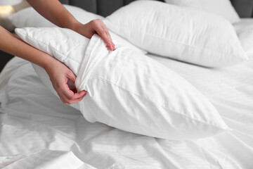 Woman changing clean bed linens at home, closeup