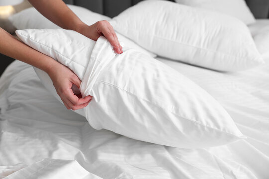 Woman changing clean bed linens at home, closeup