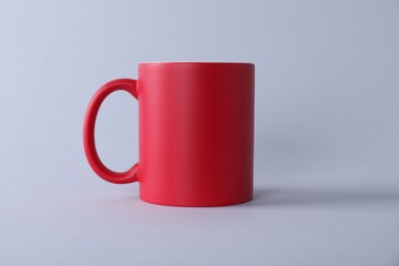 One blank red mug on light background. Mockup for design