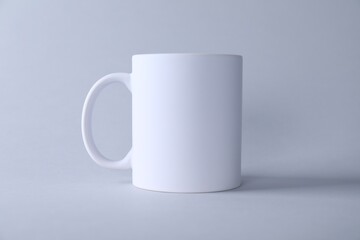 One blank white mug on light background. Mockup for design