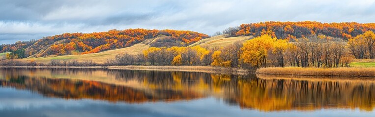 Breathtaking autumn panorama showcasing vibrant fall foliage reflecting on calm waters in a tranquil landscape