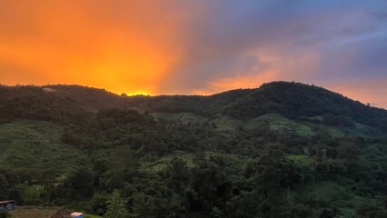 Panoramic view of mountain range under colorful blue and orange after sunset.