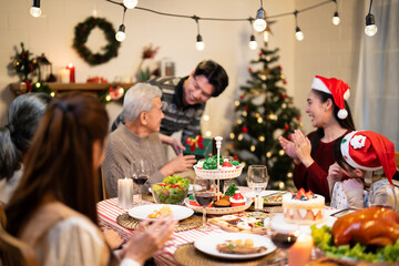 Asian festive gathering featuring a holiday dinner with family, decorated table, Christmas tree, and cheerful decorations, creating a warm, celebratory atmosphere