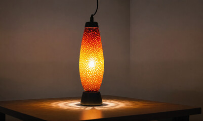 A lava lamp casts a warm glow on a wooden table