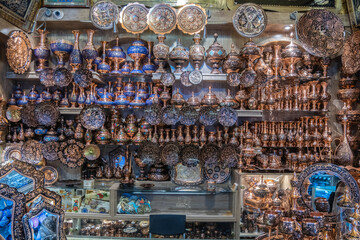 A shelf filled with colorful plates and vases of various shapes, Shiraz, Iran