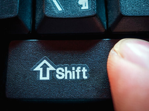 Close-up of finger pressing the Shift  key on the keyboard.