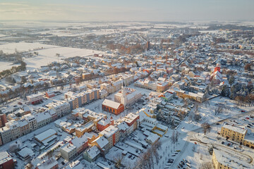 Obraz premium Aerial view of city center and residential neighborhood with houses and road streets covered in snow. Winter season in small European town