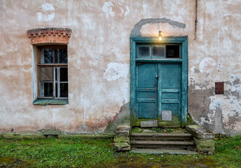 Weathered door and vintage window on abandoned building with rustic charm